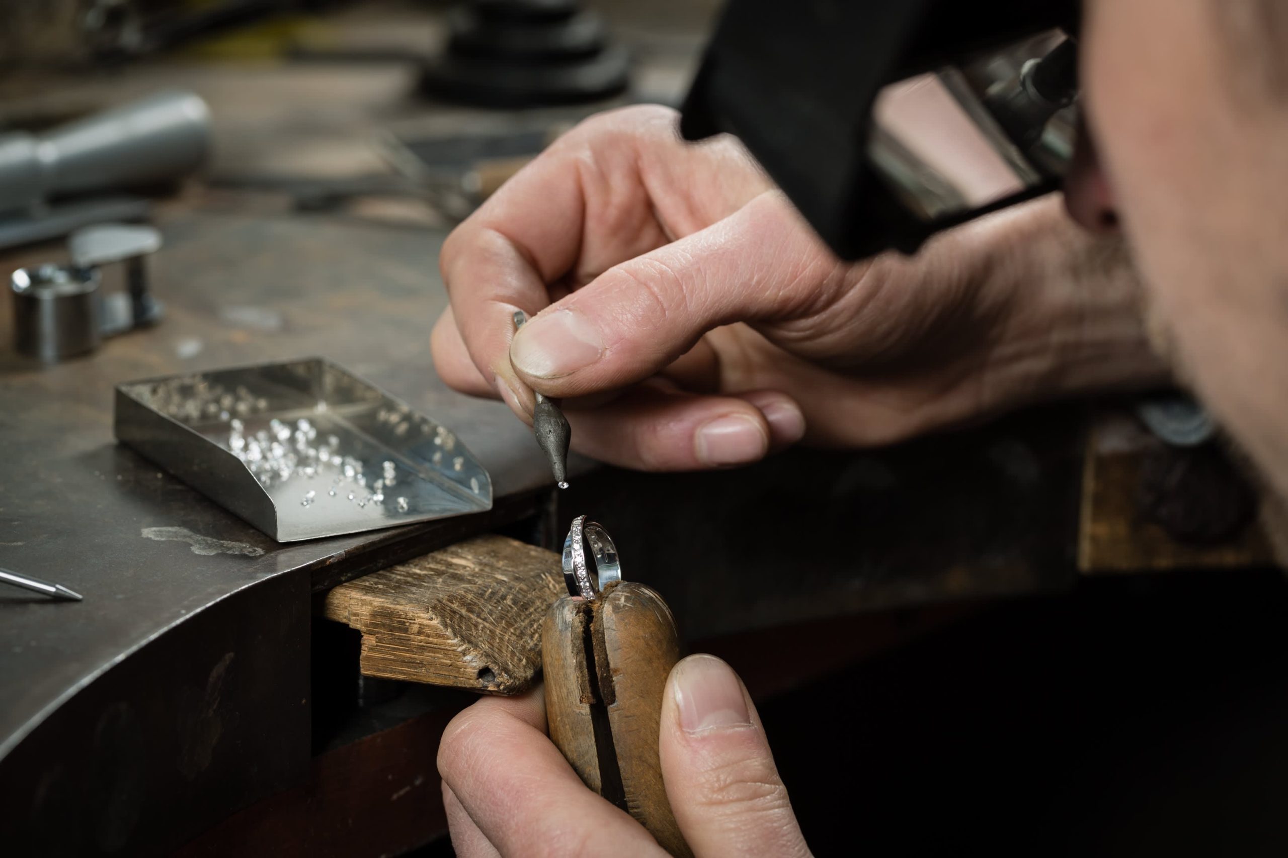 Jeweler at workbench performing repair on a ring