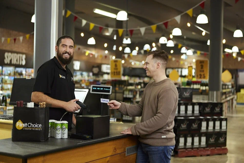 Customer being served at liquor store with gift card and loyalty card